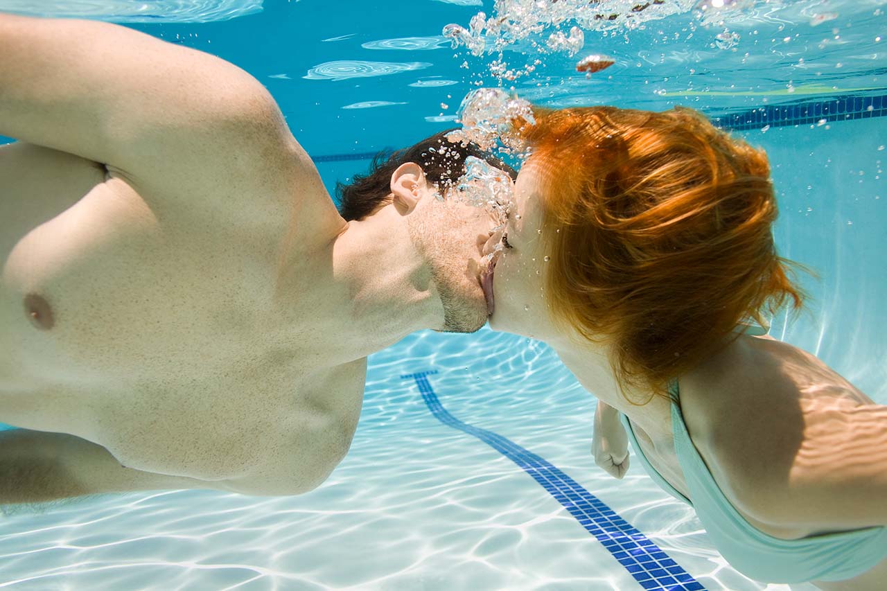 Casal super apaixonado experimentando um dos tipos de beijo embaixo d’água. 