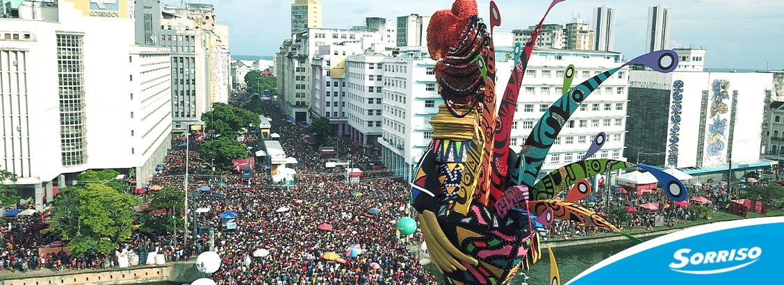 Pedaço de carvão sobre uma folha de bananeira, ao lado de uma tigela com carvão em creme.