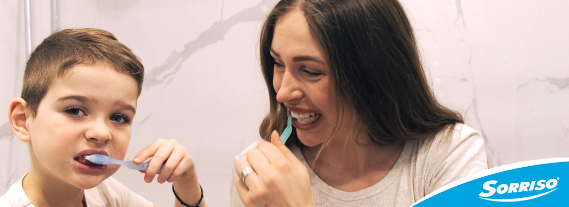 Filho e mae escovando os dentes