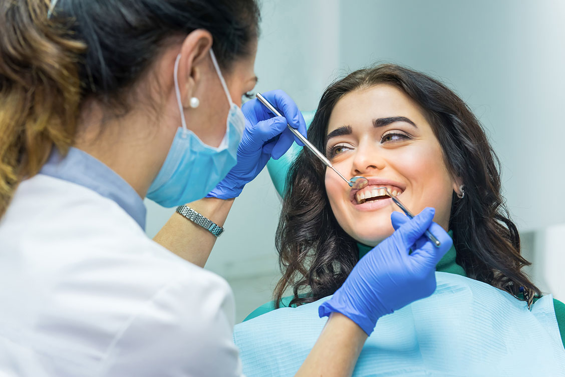 Mulher sendo examinada pela dentista para ver se tem cárie no dente Mulher sendo examinada pela dentista para ver se tem cárie no dente